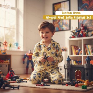 Puede incluir: Conjunto de pijama de sat&eacute;n amarillo con estampado integral y dise&ntilde;o de dibujos animados. El pijama incluye una camisa con botones y pantalones a juego. La imagen muestra a un ni&ntilde;o usando el pijama y jugando con juguetes.