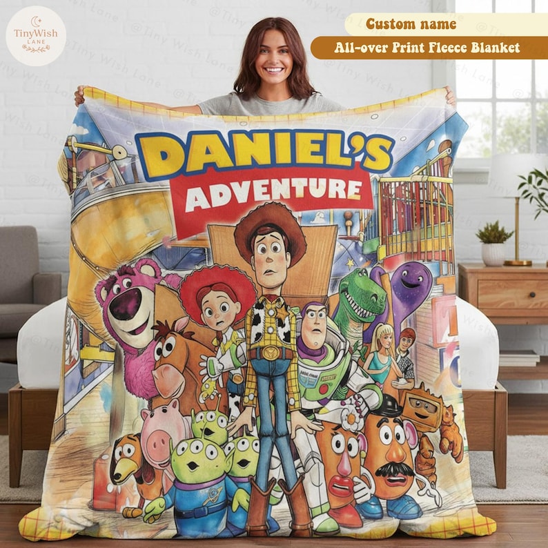 May include: A fleece blanket featuring a colorful Toy Story character print with the text DANIEL'S ADVENTURE. The design includes Woody, Buzz Lightyear, Jessie, Lotso, Rex, and other characters in a room setting with a yellow and red banner.