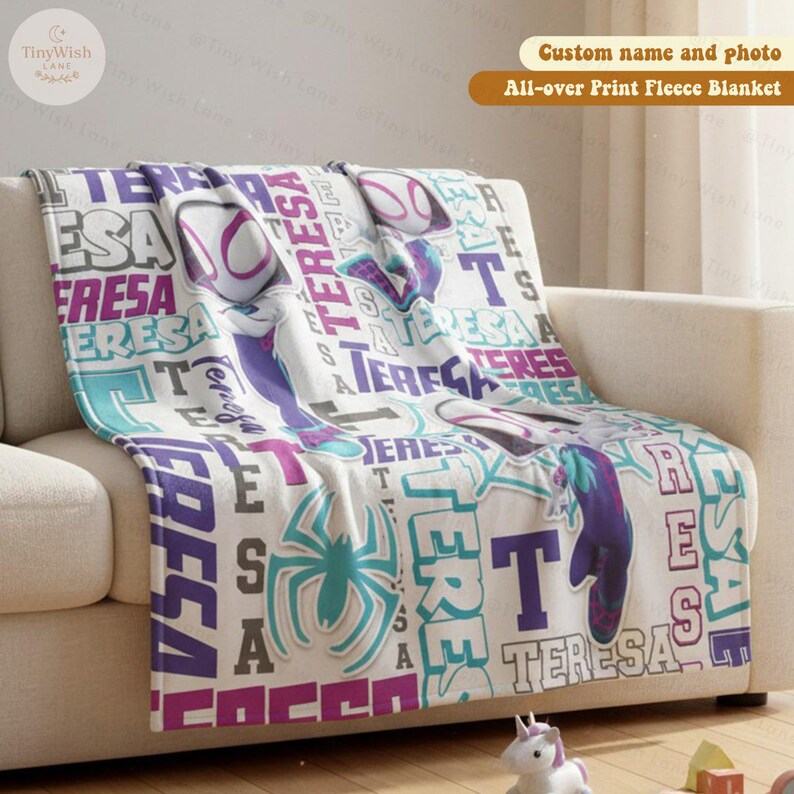Może przedstawiać: Biały polarowy koc z niestandardowym wzorem z imieniem "TERESA" w kolorze fioletowym, turkusowym i białym. Koc ma powtarzający się wz&oacute;r z grafiką pająka i tekstem "All-over Print Fleece Blanket".
