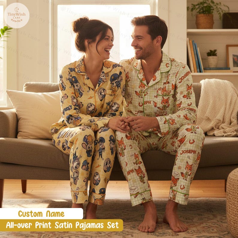 Puede incluir: Conjunto de pijama de sat&eacute;n a juego con estampado integral. Un conjunto es amarillo con personajes de dibujos animados, el otro es verde claro con zorros. El texto "Custom Name" y "All-over Print Satin Pajamas Set" son visibles.