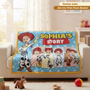 Może przedstawiać: Niebieski polarowy koc z postacią Jessie z Toy Story. Koc ma niestandardową nazwę i słowa "SOPHIA'S STORY" w kolorze czerwonym. Koc jest ozdobiony wizerunkami Jessie i ż&oacute;łtą obw&oacute;dką.