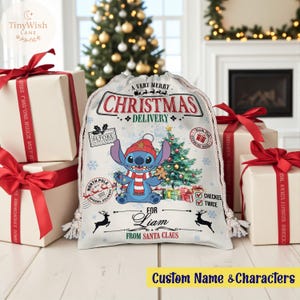 Puede incluir: Una bolsa de regalo navideña blanca con cierre de cordón, con un personaje de dibujos animados, un árbol de Navidad y el texto "CHRISTMAS DELIVERY". Regalos envueltos con cintas rojas rodean la bolsa. El texto "FOR Liam FROM SANTA CLAUS" también es visible.