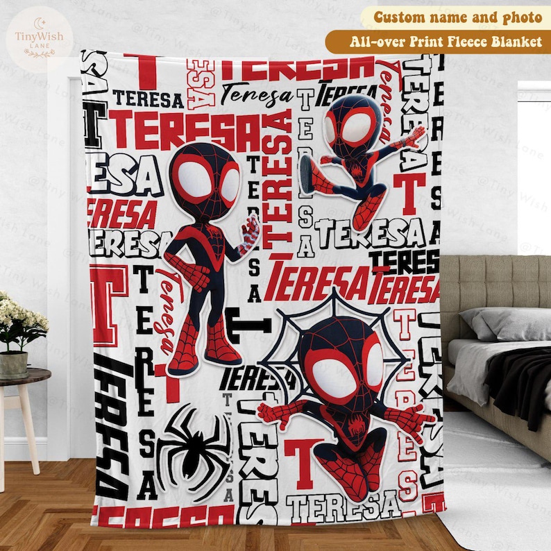 Może przedstawiać: Biały polarowy koc z powtarzającym się wzorem imienia "TERESA" w kolorze czerwonym i czarnym. Koc przedstawia r&oacute;wnież ilustracje kresk&oacute;wkowego superbohatera w kolorze czerwonym i czarnym. Tekst "Custom name and photo" znajduje się na g&oacute;rze.