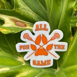 May include: White sticker with orange text and a paw print design. The text reads "ALL FOR THE GAME".