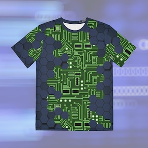 May include: A short-sleeved t-shirt featuring a green circuit board design over a dark blue hexagonal pattern. The circuit board design is detailed with lines, squares, and circles, creating a tech-inspired aesthetic. The shirt has a white crew neck.
