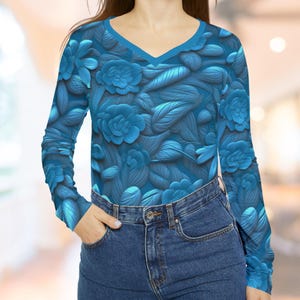 May include: A long-sleeved shirt with a blue floral pattern. The shirt has a V-neck and is made of a soft, stretchy fabric.
