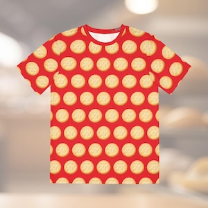 May include: A red t-shirt with a pattern of round, light brown crackers.
