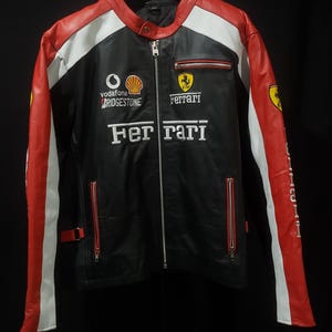 May include: Black leather jacket with red and white accents. Features the Ferrari logo and sponsor logos. Includes a zipper closure and multiple pockets. A stylish racing-inspired jacket.