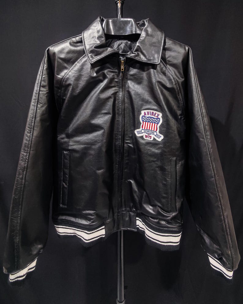 May include: A white ceramic mug with a black handle and the text "But First, Coffee" in a black, bold font. The mug is on a white surface. The mug is approximately 4 inches tall.