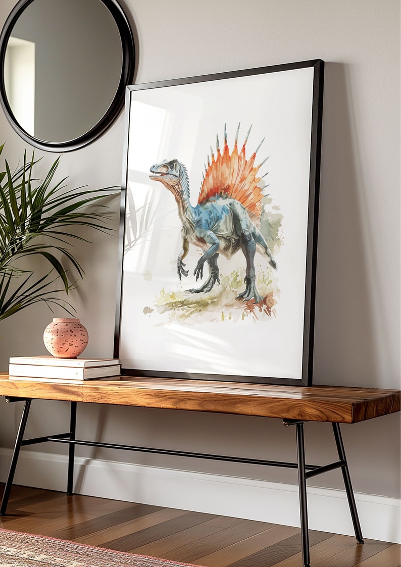 Puede incluir: Impresi&oacute;n en acuarela enmarcada de un dinosaurio Spinosaurus. La obra de arte presenta un dinosaurio azul y gris con una vela naranja y roja. La impresi&oacute;n enmarcada se exhibe en un banco de madera.