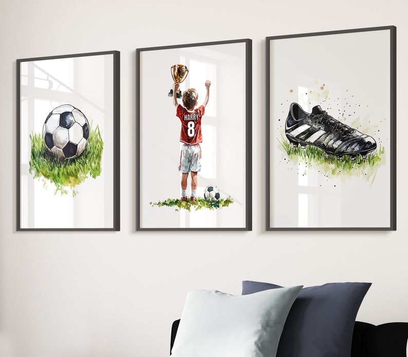 May include: Three framed watercolour paintings depicting a football player holding a trophy, a football, and a football boot. The player is wearing a red jersey with the number 8 and the name "Harry" on the back.