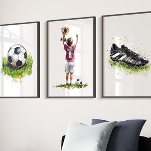 May include: Three framed watercolour paintings depicting a football player holding a trophy, a football, and a football boot. The player is wearing a red and white jersey with the number 8 and the name "Harry" on the back.