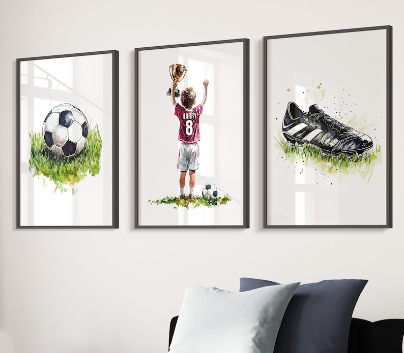 May include: Three framed watercolour paintings depicting a football player holding a trophy, a football, and a football boot. The player is wearing a red and white jersey with the number 8 and the name "Harry" on the back.