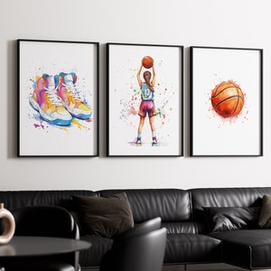 May include: A triptych of framed watercolour prints with basketball themes. One print depicts colourful basketball trainers, another a basketball player shooting, and the last a basketball. The prints have white backgrounds and black frames.