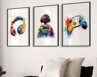 May include: Three framed watercolour paintings with a colourful theme. The first painting features a pair of headphones with a splash of colour behind them. The second painting features a person wearing a colourful hoodie with a splash of colour behind them. The third painting features a colourful video game controller with a splash of colour behind it.
