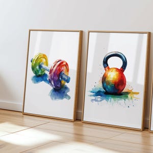 May include: Two watercolor paintings of gym equipment. The first painting shows a colorful dumbbell with a rainbow color scheme. The second painting shows a colorful kettlebell with a rainbow color scheme.