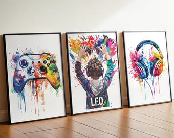Peut inclure: Trois affiches encadrées avec des motifs de style aquarelle. L'affiche de gauche montre une manette de jeu, celle du centre représente une personne tenant une manette avec le nom LEO imprimé en dessous, et celle de droite affiche un casque audio.