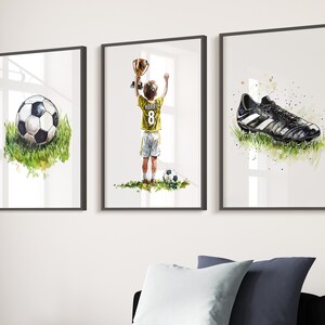May include: Three framed watercolour paintings depicting a football player holding a trophy, a football, and a football boot. The player is wearing a yellow jersey with the number 8 and the name "Harry" on the back.