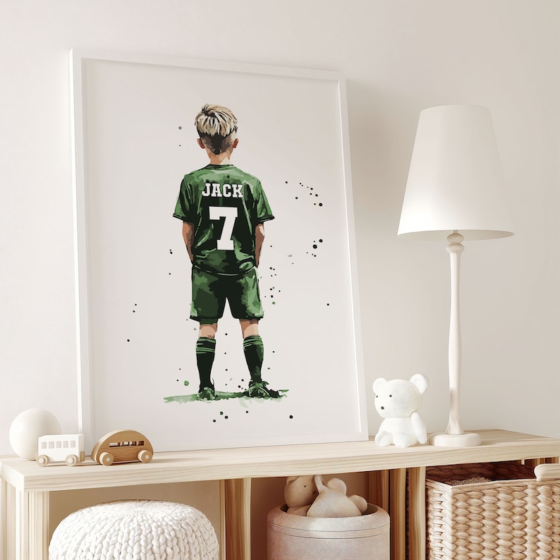 K&ouml;nnte beinhalten: Eine gerahmte Illustration eines jungen Menschen, der ein gr&uuml;nes Fu&szlig;balltrikot mit dem Namen "JACK" und der Nummer "7" auf dem R&uuml;cken tr&auml;gt. Die Person steht mit dem R&uuml;cken zum Betrachter und blickt nach links. Der Hintergrund ist wei&szlig; mit kleinen schwarzen Punkten.