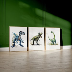 Puede incluir: Tres pinturas de acuarela enmarcadas de dinosaurios. La primera pintura presenta un velociraptor azul, la segunda pintura presenta un Tyrannosaurus Rex verde y la tercera pintura presenta un Brachiosaurus verde.