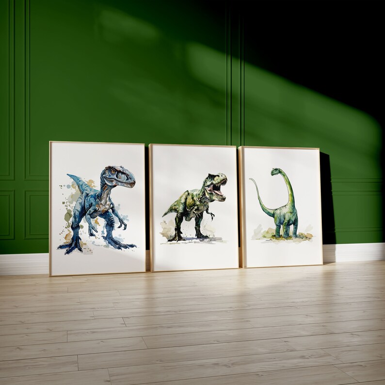 Puede incluir: Tres pinturas de acuarela enmarcadas de dinosaurios. La primera pintura presenta un velociraptor azul, la segunda pintura presenta un Tyrannosaurus Rex verde y la tercera pintura presenta un Brachiosaurus verde.
