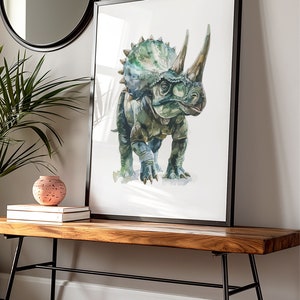 Puede incluir: Impresi&oacute;n en acuarela de un dinosaurio Triceratops en tonos verdes y azules, enmarcada en negro. La obra de arte se exhibe sobre un banco de madera con patas de metal negro, junto a un jarr&oacute;n decorativo y libros. Un espejo redondo cuelga en la pared.