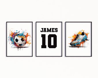 Könnte beinhalten: Drei gerahmte Drucke mit Fußball-Motiv. Der erste Druck zeigt einen Fußball mit bunten Farbschleudern. Der zweite Druck hat den Namen "JAMES" und die Nummer "10" in schwarzem Text. Der dritte Druck zeigt einen Fußballschuh mit bunten Farbschleudern.
