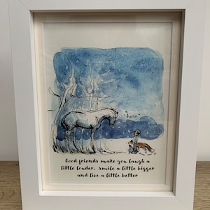May include: White framed art print with a watercolour illustration of a horse, child, and fox under a blue sky. The print includes the word "hello" and a quote about friendship. The frame is white.