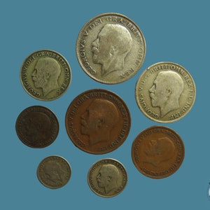 May include: A collection of antique coins, featuring various sizes and metallic finishes, arranged on a blue background. The coins display profiles of a monarch and inscriptions. The image includes the Countryside Coins logo in the bottom right corner.