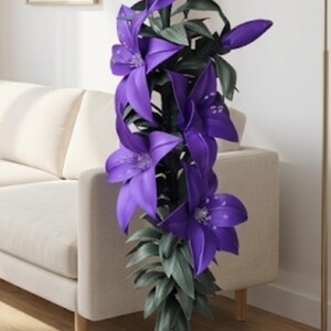 Puede incluir: Una planta decorativa vertical alta que presenta m&uacute;ltiples flores grandes de color p&uacute;rpura vibrante en forma de lirio con p&eacute;talos puntiagudos y hojas alargadas de color verde oscuro. La planta se sostiene mediante un tallo central oscuro que se enrolla en una base circular.
