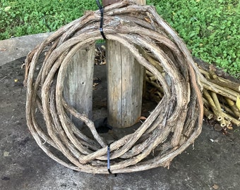 May include: A large bundle of dried vines is tied together with black zip ties and wrapped around a wooden post.