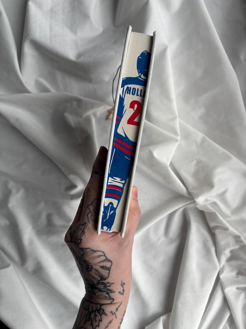 May include: A book spine featuring a blue and red illustration of a football player with the number 2. The word "HOLL" is printed above the number. The book has a white spine and a cream-colored cover.