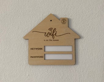 May include: A wooden house-shaped sign with the text "wifi is on the house" and blank spaces for "NETWORK" and "PASSWORD".