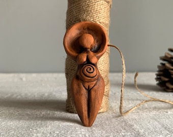 Diosa madre embarazada de cerámica. Figura femenina de arcilla. Amuleto de fertilidad.