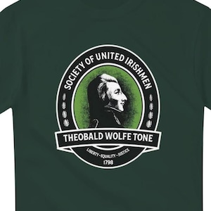 Könnte beinhalten: Ein grünes T-Shirt mit einem weißen Kreis-Motiv, das ein Porträt von Theobald Wolfe Tone, den Text "Society of United Irishmen" und den Text "Liberty - Equality - Justice 1798" zeigt.