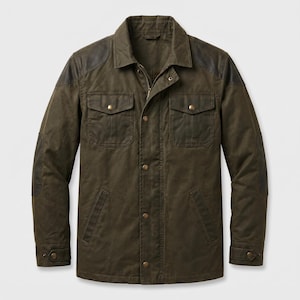 Könnte beinhalten: Eine olivgrüne Feldjacke mit durchgehendem Frontreißverschluss und Druckknopfleiste. Die Jacke verfügt über zwei Brusttaschen mit Druckknopfklappen, zwei untere Eingrifftaschen sowie dunkelbraune Schulter- und Ellbogenbesätze.