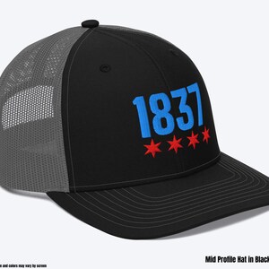 May include: A black and charcoal gray trucker hat with a blue and red embroidered design. The design features the number "1837" and five red stars.