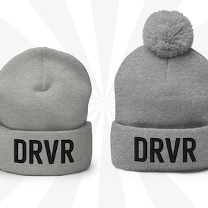 May include: Two gray knit beanies with a black "DRVR" logo. One beanie has a fluffy pom pom on top.