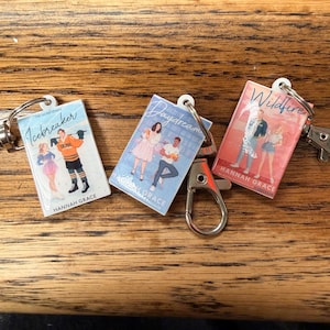 May include: A white ceramic mug with a black handle and the text "But First, Coffee" in a black, bold font. The mug is on a white surface.