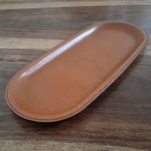 An attractive handcrafted leather decorative multifunctional storage / valet tray, keeping your daily accessories in one place.