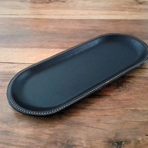 An attractive handcrafted leather decorative multifunctional storage / valet tray, keeping your daily accessories in one place.