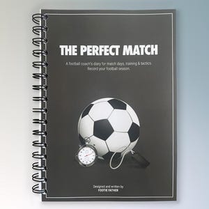 May include: A black and white spiral bound notebook with the title "The Perfect Match" and a football, whistle, and stopwatch illustration. The text below the title reads "A football coach's diary for match days, training & tactics. Record your football season." The bottom of the notebook says "Designed and written by FOOTIE FATHER."