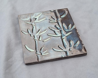 Sottopentola in ceramica fatta a mano, azzurro chiaro, con decorazione a foglie.
