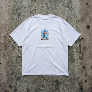K&ouml;nnte beinhalten: Wei&szlig;es T-Shirt mit Rundhalsausschnitt und kurzen &Auml;rmeln. Das Shirt hat eine runde Grafik mit einem Tukan, einem Pint Bier und dem Text "Guinness is good for you."