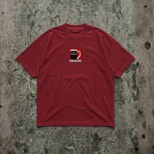 May include: A maroon t-shirt featuring a small graphic of a Guinness pint glass with the brand name below. The shirt has short sleeves and a crew neck. The graphic is in red, white, and black.