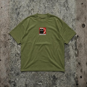 May include: Olive green t-shirt featuring a square graphic of a Guinness pint glass with the brand name below. The graphic is red, black, and white. The shirt has short sleeves and a crew neck.
