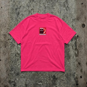 May include: A bright pink t-shirt featuring a small, rectangular graphic of a Guinness pint glass. The graphic is in red, black, and white, with the Guinness logo at the bottom. The shirt is made of a soft material.