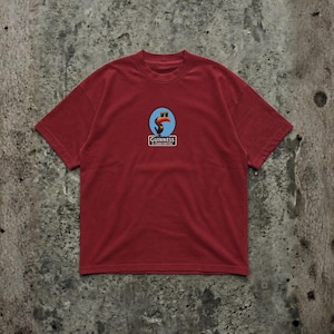 K&ouml;nnte beinhalten: Ein weinrotes T-Shirt mit kurzen &Auml;rmeln und einem kreisf&ouml;rmigen Logo mit einem Tukan, zwei blauen Kreisen und dem Text "Guinness" in einem wei&szlig;en Rechteck. Das Shirt ist aus weichem Material.