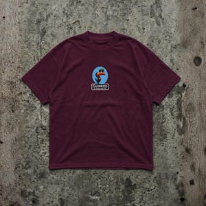 K&ouml;nnte beinhalten: Burgunderfarbenes T-Shirt mit einem Guinness-Logo, das einen Tukan mit einem Guinness-Pint zeigt, mit dem Text "Guinness is good for you". Das Shirt hat einen Rundhalsausschnitt und kurze &Auml;rmel.