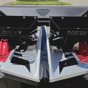 Puede incluir: Un veh&iacute;culo plateado y negro con detalles en rojo. El veh&iacute;culo lleva la palabra "ROUSH" en paneles negros. La parte delantera del veh&iacute;culo tiene un dise&ntilde;o geom&eacute;trico con faros integrados. El veh&iacute;culo est&aacute; estacionado sobre una superficie pavimentada.